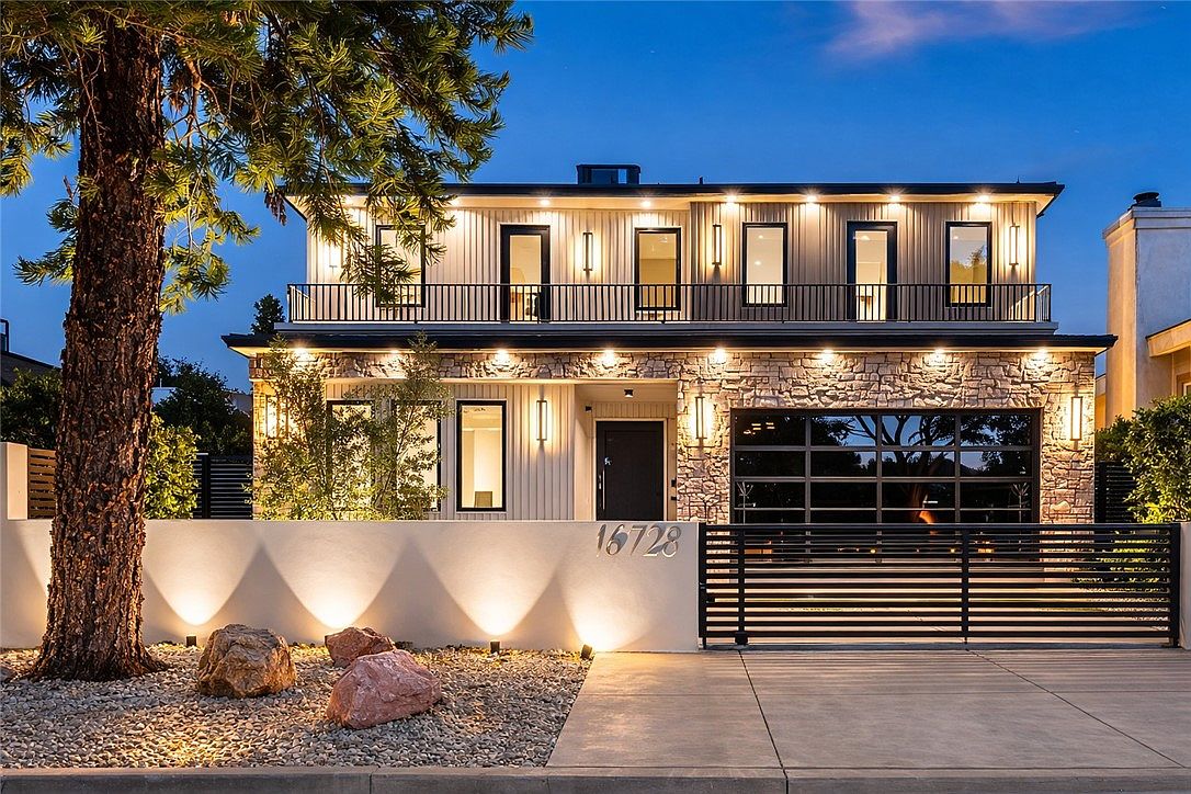 Front exterior at night with dramatic lighting and stone accents